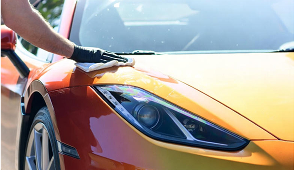 A man applying polish to a supercar
